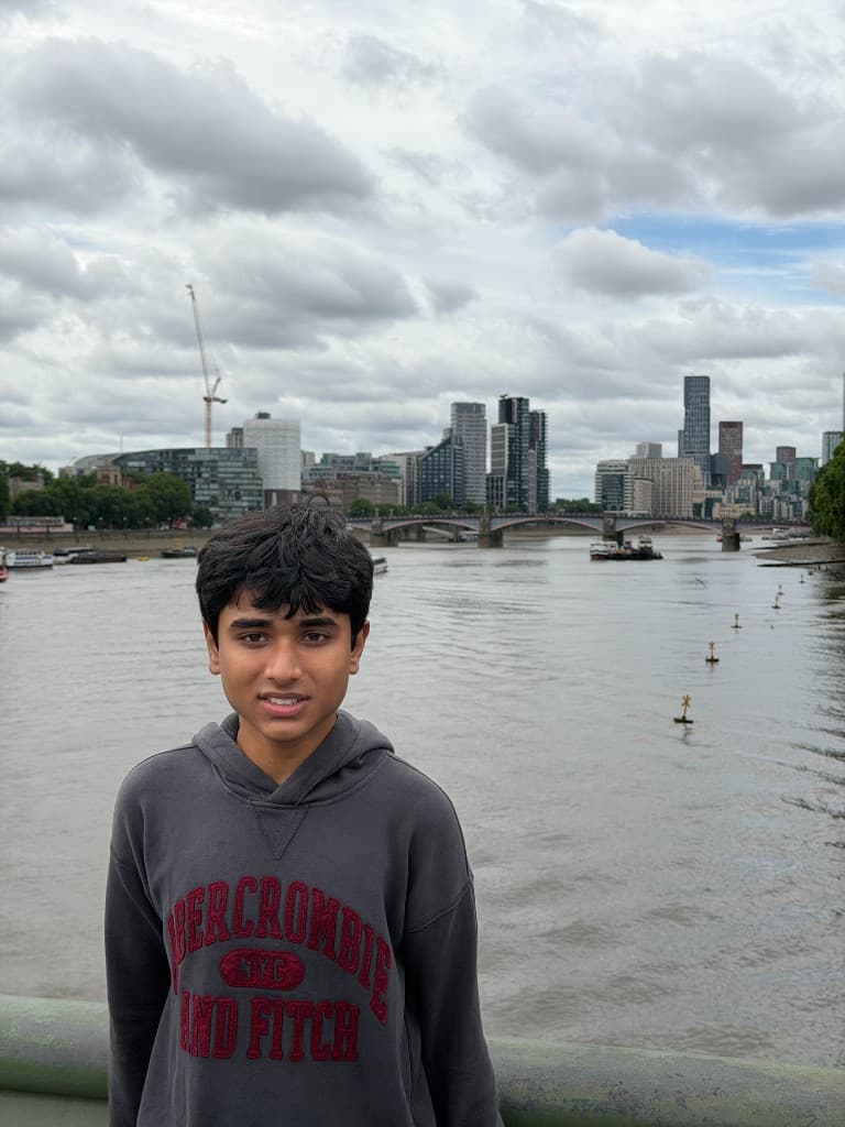 Sudhith Mannuru standing on a bridge with a river and city skyline behind him.